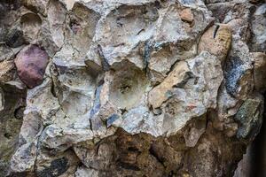 A large rock wall with many different colored rocks photo