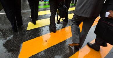 People walking across a street with yellow and orange stripes photo