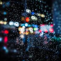 Raindrops on a window at night with traffic lights photo