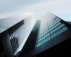 Two tall buildings are seen from below photo