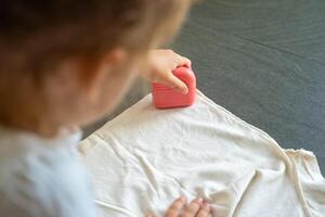 Back view of little girl with a stamp with a name for signing children's things. Identification of personal clothing. High quality photo