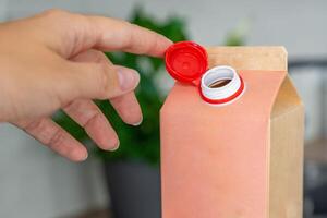 Long-life cardboard container from recycling materials with stationary plastic cap. Cap remains attached after opening, making the entire package easier to collect and recycle. High quality photo