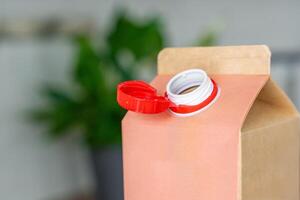 Long-life cardboard container from recycling materials with stationary plastic cap. Cap remains attached after opening, making the entire package easier to collect and recycle. High quality photo