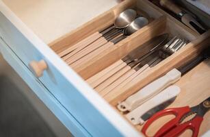 Open kitchen drawer with silverware , Kitchenware and dining accessories in drawer photo