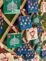 Eco-friendly zero waste large advent calendar in the form of a Christmas tree with craft bags and macrame on the wall. High quality photo