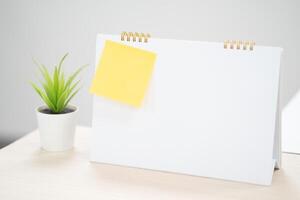Yellow sticky notes on blank desk calendar at business office with copy space for text,selective color. photo