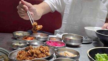 Crop anonymous man with chopsticks eating yummy Yeoltan Bulgogi and meat in gray bowl at Korean restaurant. photo