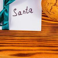 note to Santa with ribbon on the board and cookies next to it, concept photo