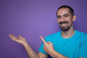 Young man pointing empty space using hands and fingers, isolated over violet background photo