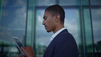 A Professional Man Using a Tablet in a Modern Urban Environment for Various Tasks and Analysis video