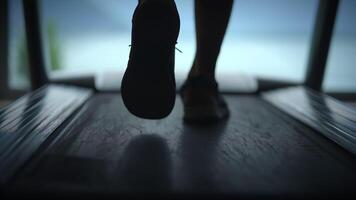 A runner on a treadmill is lit beautifully by the sunset, creating a stunning scene video