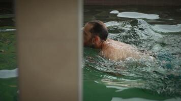 A Man Swimming in a Refreshing Pool During a Warm Summer Day enjoying the Activity video