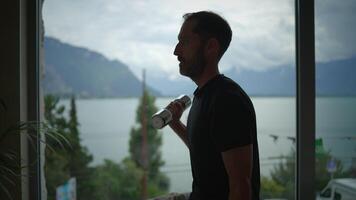 A Man Lifting Weights with a Dumbbell While Taking in a Beautiful Scenic Lake View video