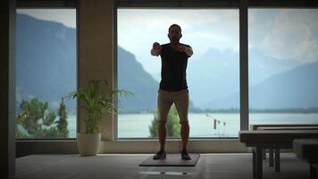 A fitness enthusiast confidently working out while enjoying a beautiful scenic mountain view video