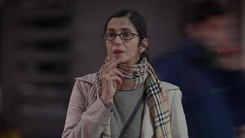 A thoughtful woman is immersed in contemplation amidst the vibrant urban setting of the city video