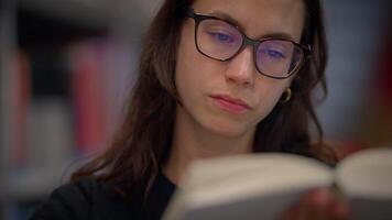 A Focused Reader, Deeply Engrossed in an Intriguing Book, While Seated Comfortably at the Library video