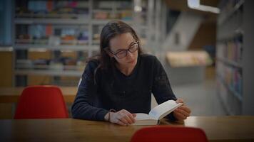 A Committed and Focused Reader Engaged in a Modern Library Setting Surrounded by Books video