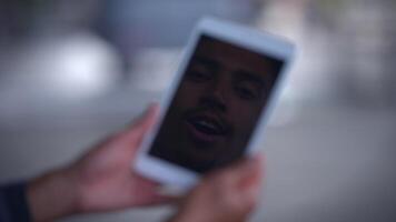 A young person is seen calling on a tablet in a vibrant and modern environment setting video