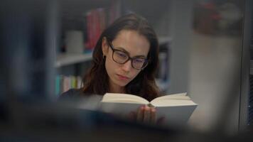 atractivo en enfocado leyendo en un contemporáneo biblioteca ambiente para mejorado aprendizaje video