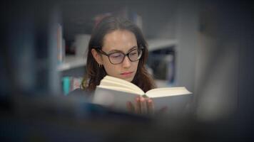 A Dedicated, Focused Reader Deeply Engrossed in an Intriguing Book Inside a Cozy Library video