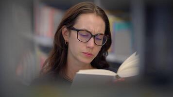 A diligent student reading and studying in a quiet library, immersed in academics video