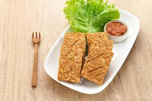 Tempe Goreng or Fried Tempeh, Indonesia traditional food, made from fermented soybean seeds. Served with sambal chilli sauce photo