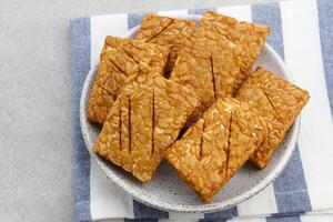 Tempeh, Tempe Goreng or Fried tempeh is Indonesia traditional food, made from fermented soybean seeds wrapped in banana leaves. Salty and savory, served as a side dish or snack. photo