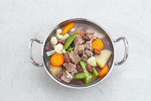 Sup daging kacang merah, clear soup with beef slices, red bean and vegetables. photo