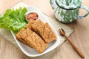 Tempe Goreng or Fried Tempeh, Indonesia traditional food, made from fermented soybean seeds. Served with sambal chilli sauce photo
