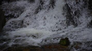 A stunningly beautiful cascading waterfall surrounded by rocks, creating a foamy stream video