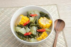 Sayur asam, sayur asem or tamarind soup is a popular traditional Indonesian soup. Common ingredients are chayote, long beans and corn with the addition of tamarind or bilimbi. Served in white bowl. photo