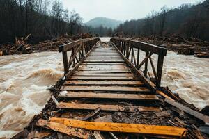 A wooden bridge partially submerged in turbulent floodwaters, surrounded by debris and trees. The landscape evokes a sense of natural disaster and environmental impact. photo