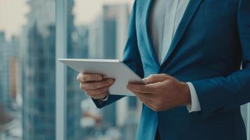 Businessman holding tablet, city skyline view, professional setting. photo