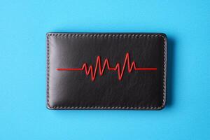 Stylish wallet with heartbeat design on a vibrant blue background. photo