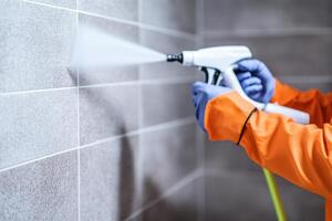 Person using a power washer on tiled surfaces, cleaning grime effectively. photo