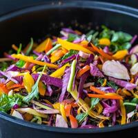 Colorful and fresh mixed salad with various vegetables in a black bowl. photo