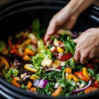 Hands mixing a colorful salad with fresh vegetables in a large bowl. photo