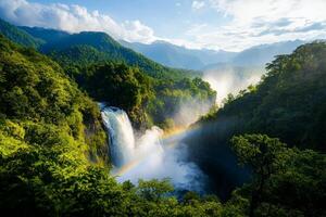Vibrant waterfall cascading through lush green mountains under a blue sky. photo