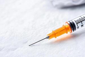Close-up of a syringe on a white background, ideal for medical themes. photo
