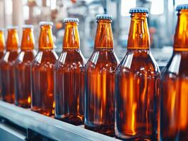 Line of amber glass bottles on a production conveyor in a brewery. photo