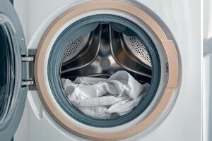 Washing machine drum with fresh laundry, white isolate background. photo