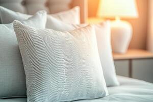 Soft white pillows on a cozy bed with warm lighting photo