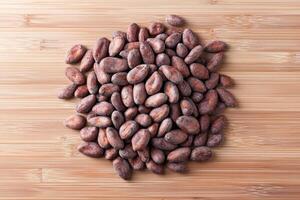 Cocoa beans on a wooden surface, natural and organic food concept. photo