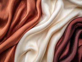 Soft, flowing silk fabric in warm colors, elegant draping on a smooth surface. photo