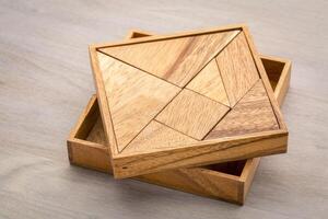 Tangram, a traditional Chinese Puzzle Game made of different wood parts to build abstract figures from them photo