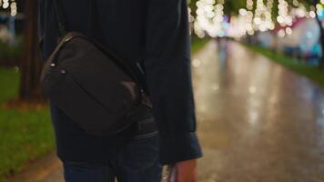 Back view of a man with a shoulder bag walking forward in a night city, sadness, depression, job disappointment, getting fired, failed negotiation, A man walking a lonely street. video