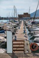 Boats docked at a peaceful marina with clear skies and calm waters photo