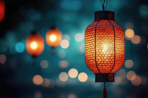 A Lit Red Chinese Lantern with a Teal Bokeh Background photo