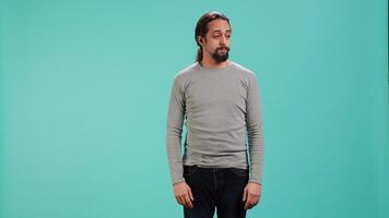 Man shrugging shoulders, unable to provide answer, having detached apathy facial expression. Apathetic person doing hand gesturing showing lack of knowledge, studio background, camera A video