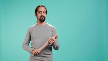Portrait of menacing man threating to hit enemy during fight. Wrathful Arab person full of rage intimidating mate, holding weapon, isolated over studio background, camera B video